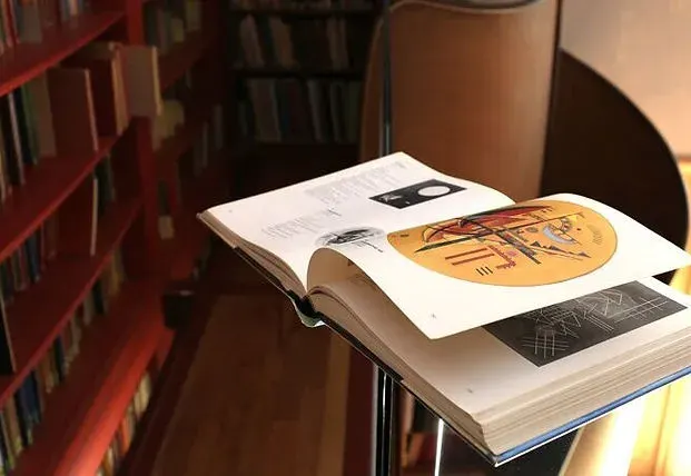 Grand livre d'art ouvert sur un pupitre en bibliothèque